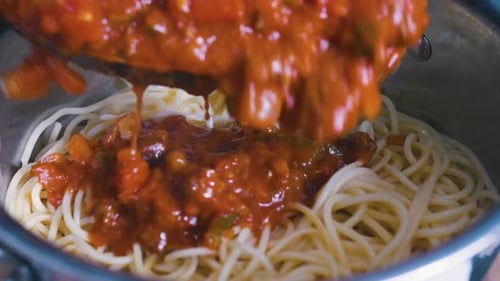 Hinzufügen von Hackfleisch, Gemüse, Tomaten-Bolognese-Sauce zu Nudelspaghetti