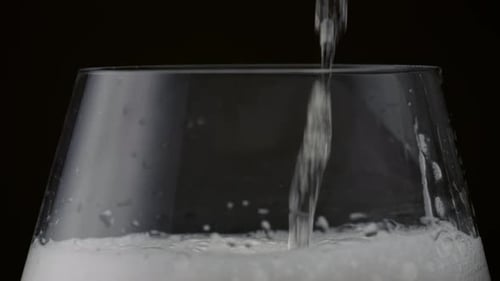 Sparkling Wine Stream Pouring Crystal Glass in Super Close Up