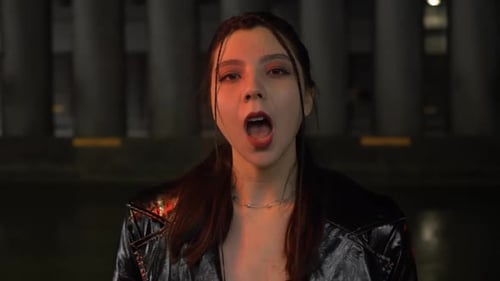 Woman Lip Syncing in the City at Night