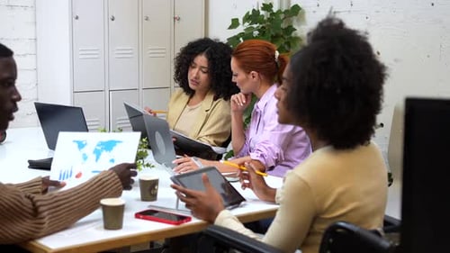 Femme handicapée et collègues travaillant dans un espace de coworking moderne