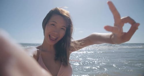 Smiling Young Woman Peace Sign Selfie on Beach