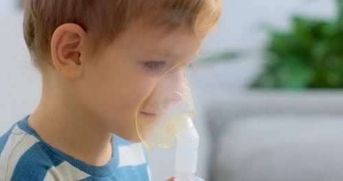 Young Boy Using Nebulizer Mask for Respiratory Treatment