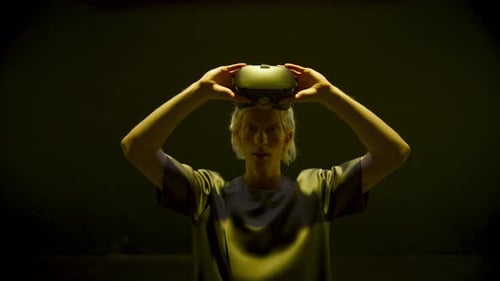 Person Puts on VR Headset in Dark Room