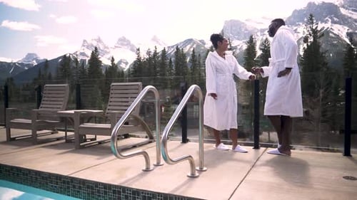 Of Couple in Robes Looking at Mountain View From Balcony