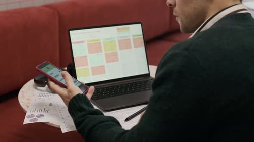 Man Works at Laptop in a Modern Workplace