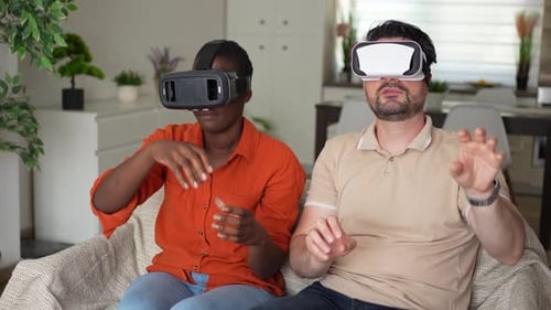 Couple using virtual reality headsets in living room