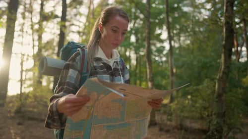 Woman with Map Hiking in Forest