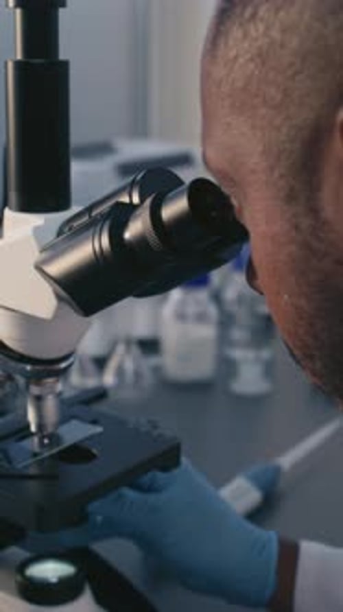 African American Scientist Analyzes Molecular Structure of Vaccine or Drug Under Microscope