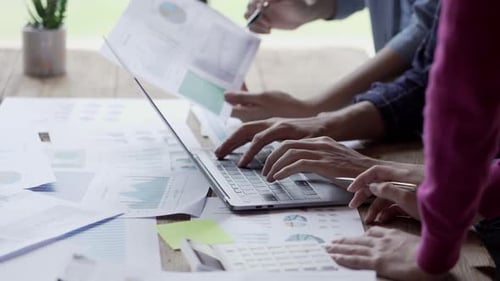 Business Team Working on Charts and Using Laptop