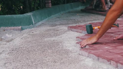 Workers Laying Down Paving Stones in Urban Setting