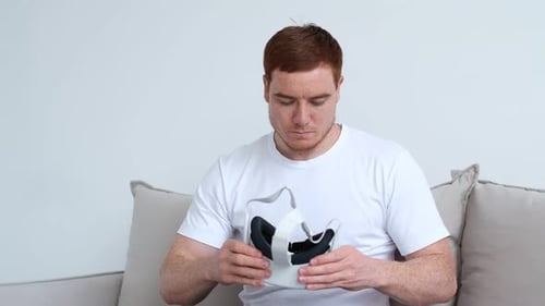 the Guy Puts on His Head a Virtual Reality Helmet