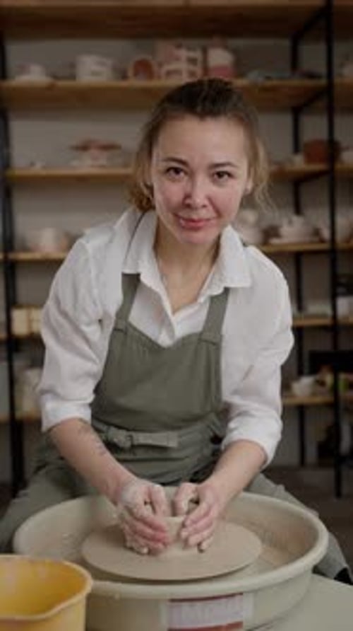Joyful Female Artisan at Pottery Wheel Molding Clay with Expertise in a Wellequipped Ceramics Studio