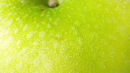 A green apple with droplets of water. macro video.
