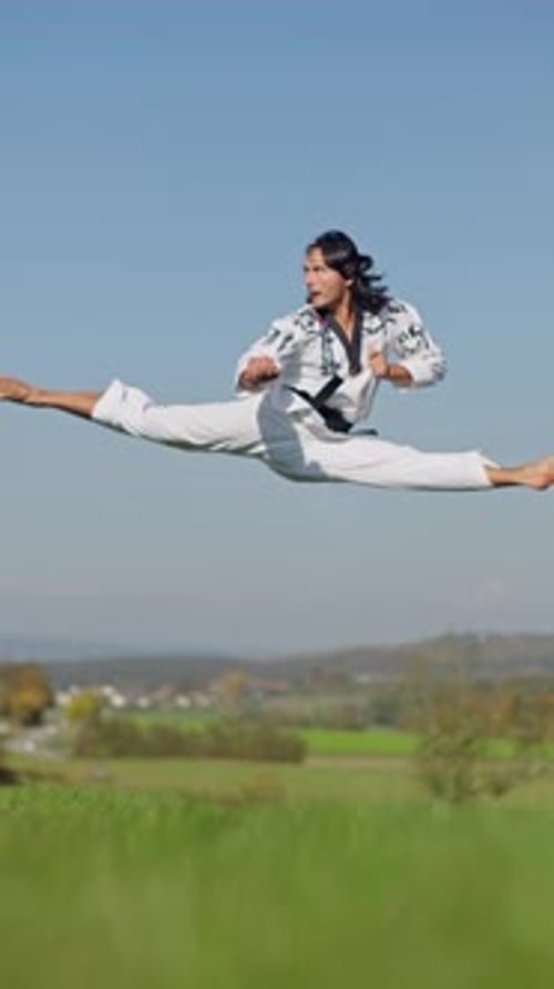 Athlete Performing a Flying Side Kick Outdoors