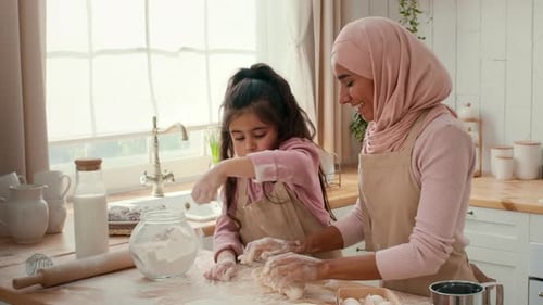 Mother and Daughter Bonding While Cooking Together in a Cozy Kitchen