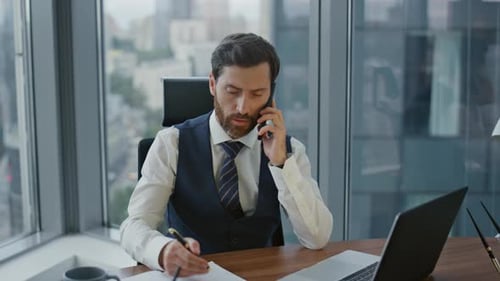Focused Businessman Talking on Phone in Office