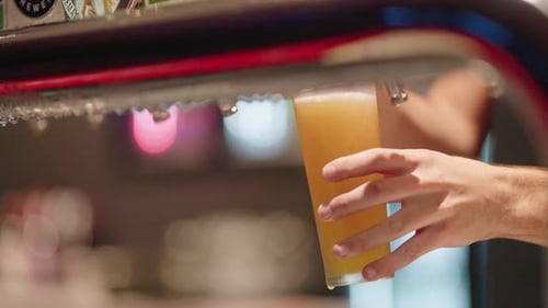 Bartender Pouring Frothy Tap Beer Into Schooner Glass At Bar, Slow Motion