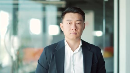 portrait of a successful confident asian male office worker standing and looking at the camera