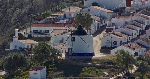 Vue aérienne d'un petit village avec moulin à vent et toits pittoresques, Odeceixe, Portugal