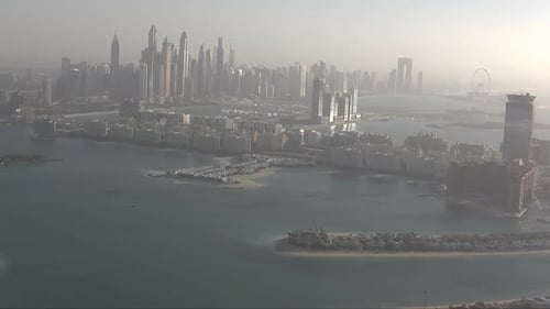 Aerial establishing shot of downtown Dubai with parts of Atlantis coming into frame