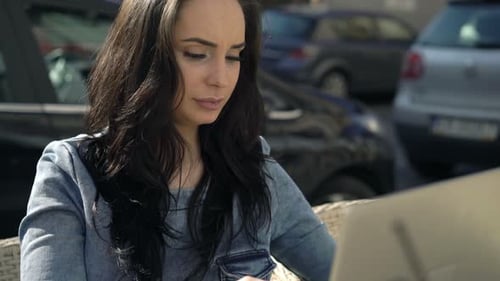 Young, Pretty Woman Using Laptop Sitting in Cafe in City 20s