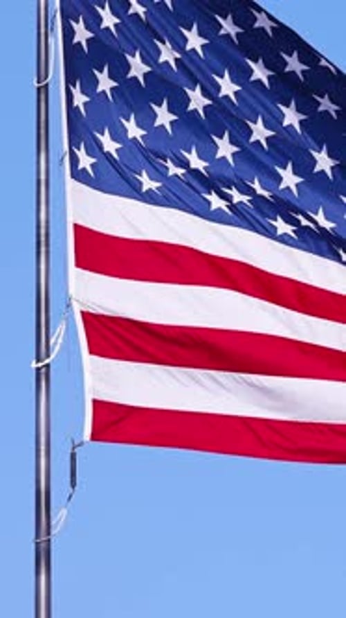 American Flag Rippling in Wind on Blue Sky