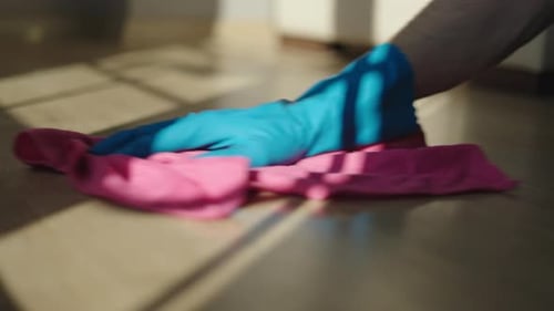 Hand Cleaning Wooden Floor with Pink Cloth