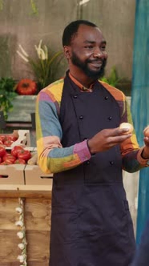 Friendly Man Stands at his Vegetable Stand