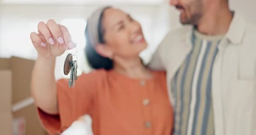 Couple, new home and keys in hand, smile and hug with excited face, investment