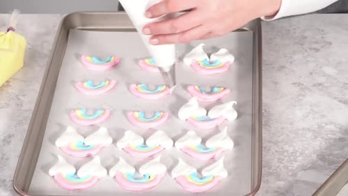 Time Lapse Step By Step Piping Meringue Mix Into Unicornshaped Pops on a Baking Sheet Lined with
