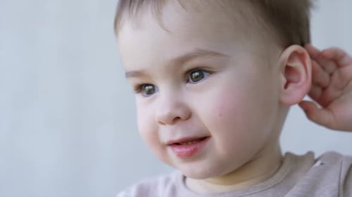 Adorable Young Boy Smiling and Reaching Upward