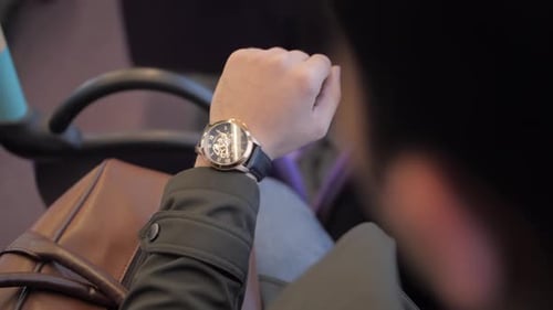Checking the time on the wristwatch.