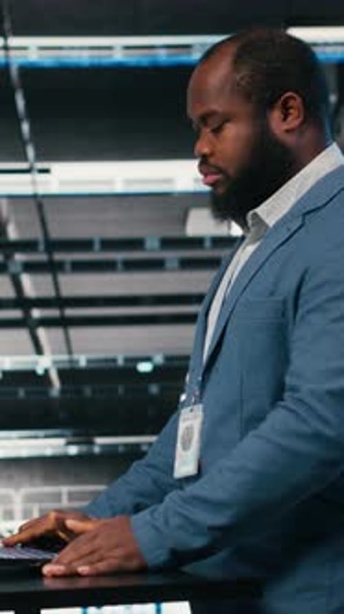 Vertical Video Using Laptop Workspace Desk and Technician in Server Hub