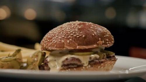 Close-up - burger with french fries on revolving table in a restaurant, a working restaurant in blur