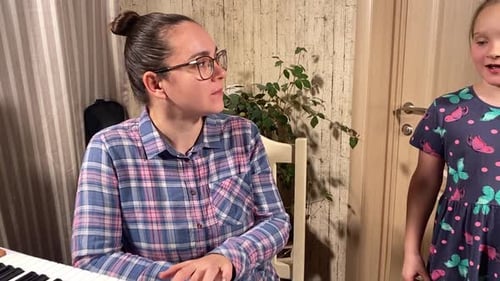 Woman Playing Keyboard with Child Beside Her