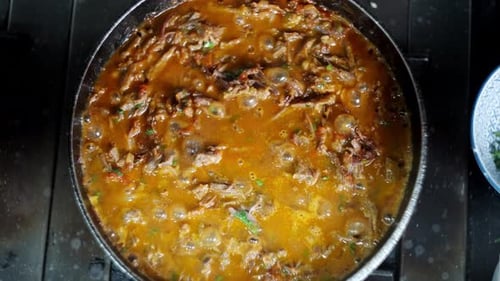 Top view down to a Bubbly and hot beef stew in a pan