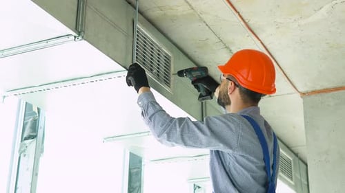 Construction Worker Installing Air Conditioning Duct