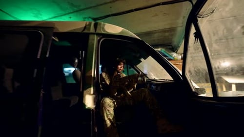 A Soldier Hides Behind a Car Holding a Weapon and Inspecting the Territory the Atmosphere of Tension