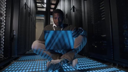 Young Adult Working on Laptop in Data Center