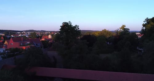 a drone rises slowly over the covered bridge overlooking the city and the city wall with the towers