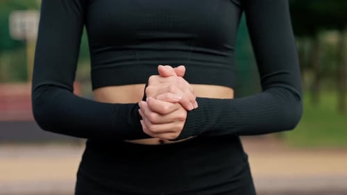 Close-up of a female athlete's hands clenched into fists while performing training exercise