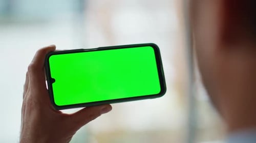 Freelancer Swiping Greenscreen Mobile Phone in Apartment Closeup Unknown Man