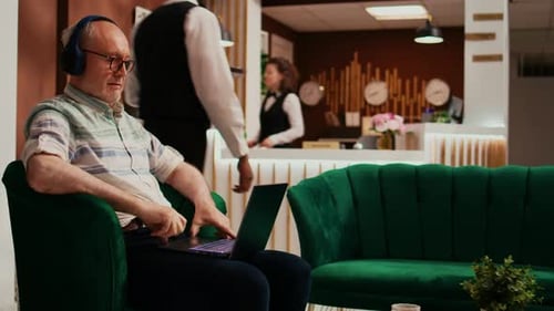 Man Uses Laptop in Elegant Hotel Lobby