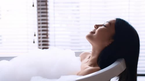 Serene Woman Relaxing in a Bubble Bath