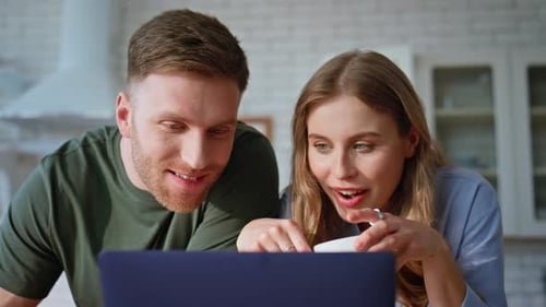 Smiling Couple Watching Laptop Together at Home