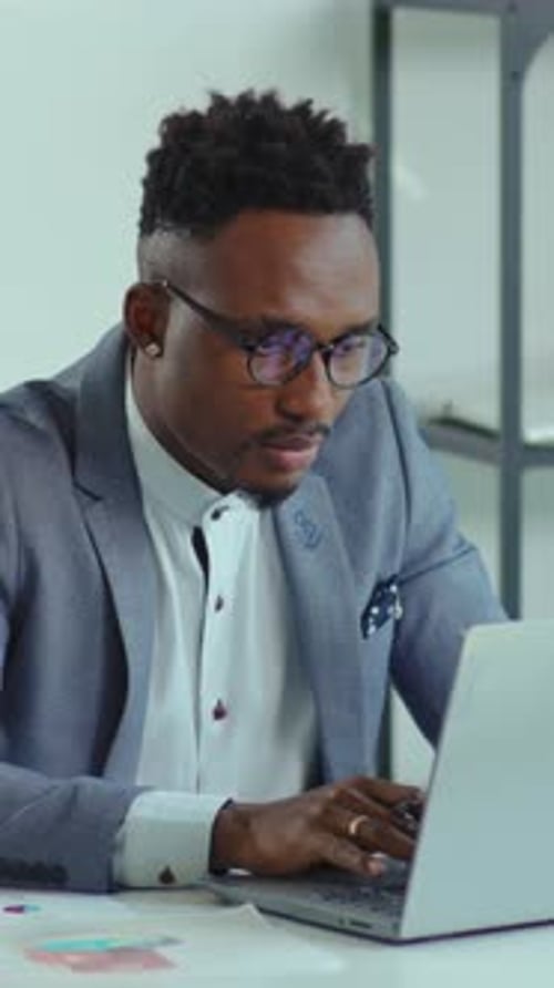 Adult Man Working on Laptop at Desk in Office