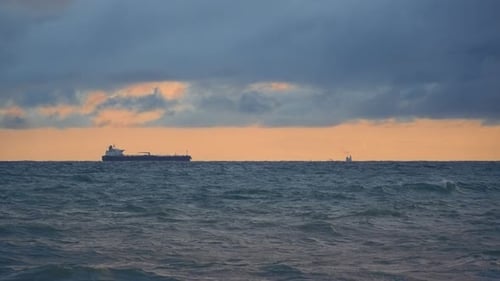 Oil Tanker in Distance Far at Sea in Sunset Pinkorange Sun Large Industrial Ship is Loading with