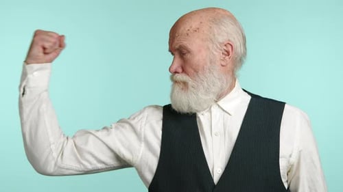 Hombre mayor que flexiona los músculos con confianza