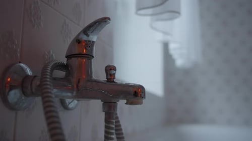 Water Dripping From the Leaking Faucet in the Bathroom