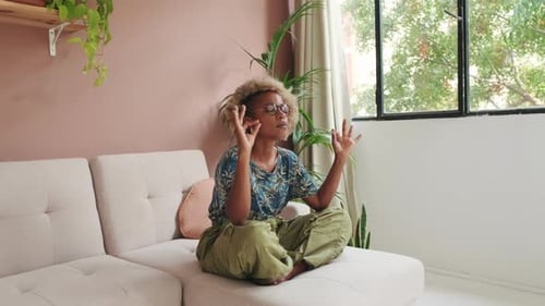 Woman Meditating on Couch in Sunny Living Room